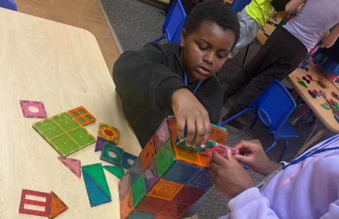  a student building a building with magnatiles